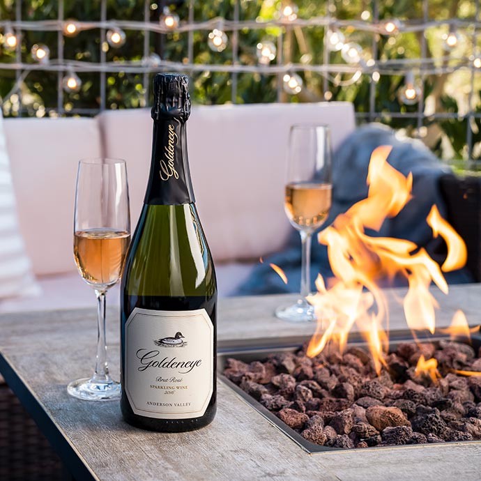 Goldeneye Sparkling next to fireplace